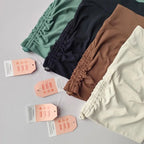 Assorted drawstring sports shorts for women in green, brown, and cream colors with hang tags