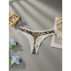 Leopard print lace underwear with white lace trim laid flat on gray surface with decorative flowers and accessories