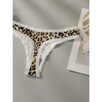 Leopard print lace underwear with white lace trim laid flat on gray surface next to a book and pearl necklace
