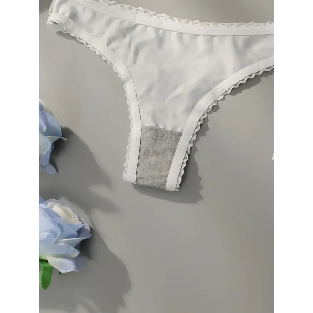 White women's underwear with lace trim on gray background styled with blue flowers without leopard print lace underwear