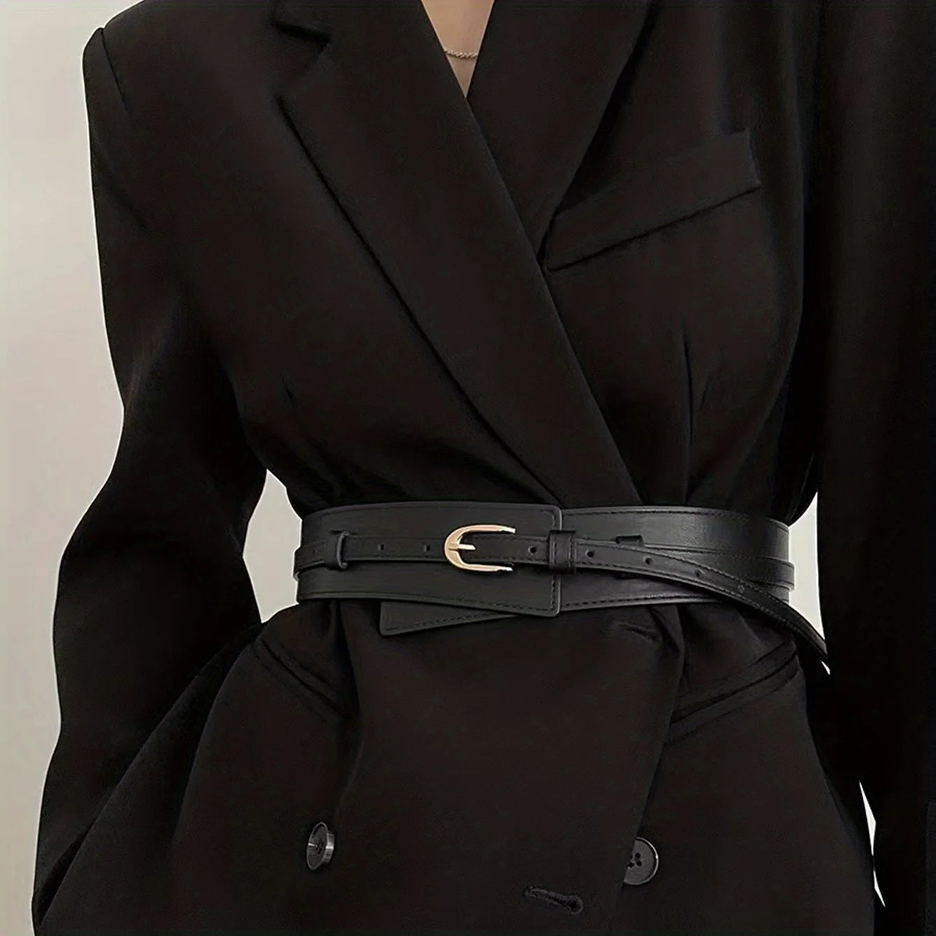 Fashionable vintage wide belt for women in black leather, styled over a black blazer