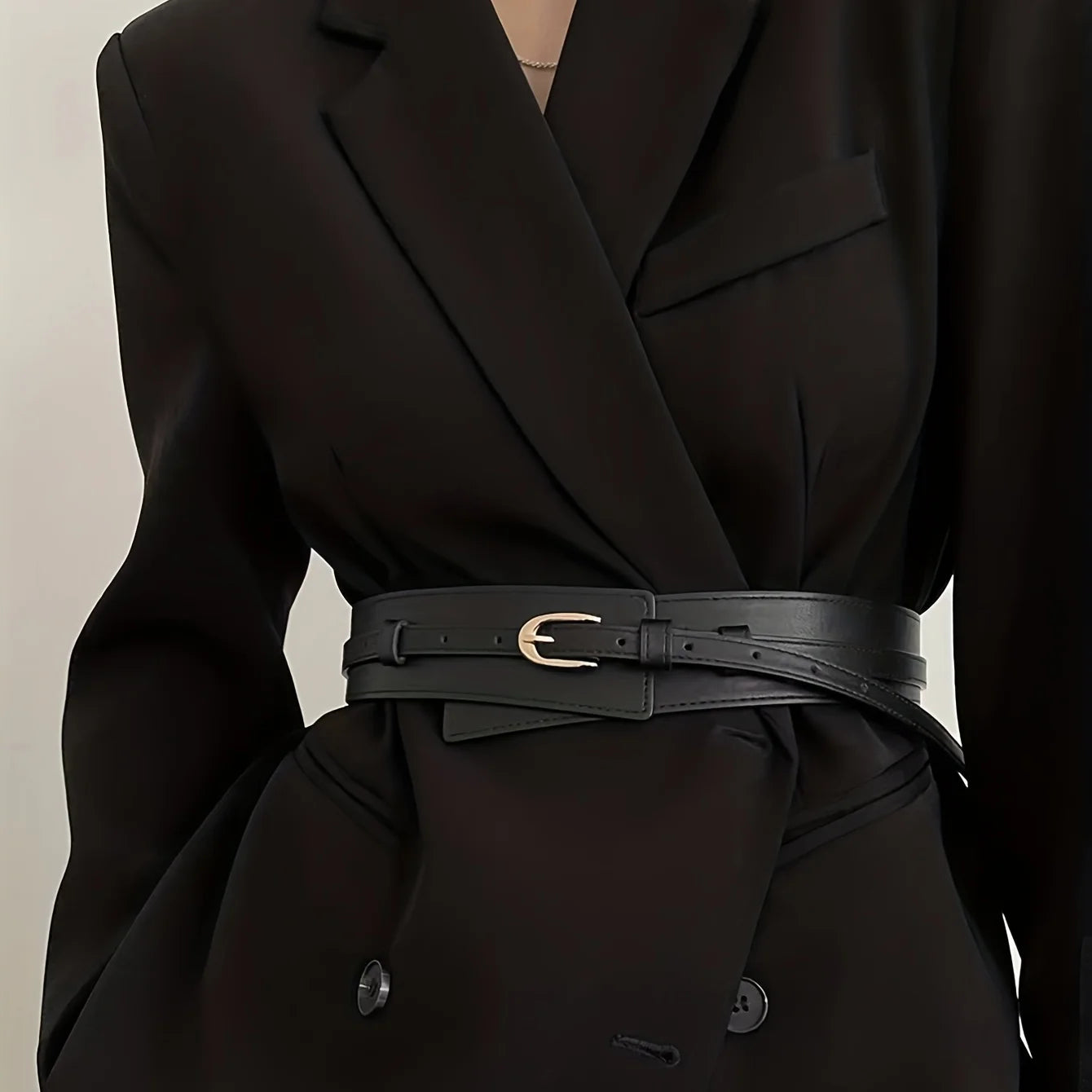 Fashionable black vintage wide belt for women styled over a tailored blazer