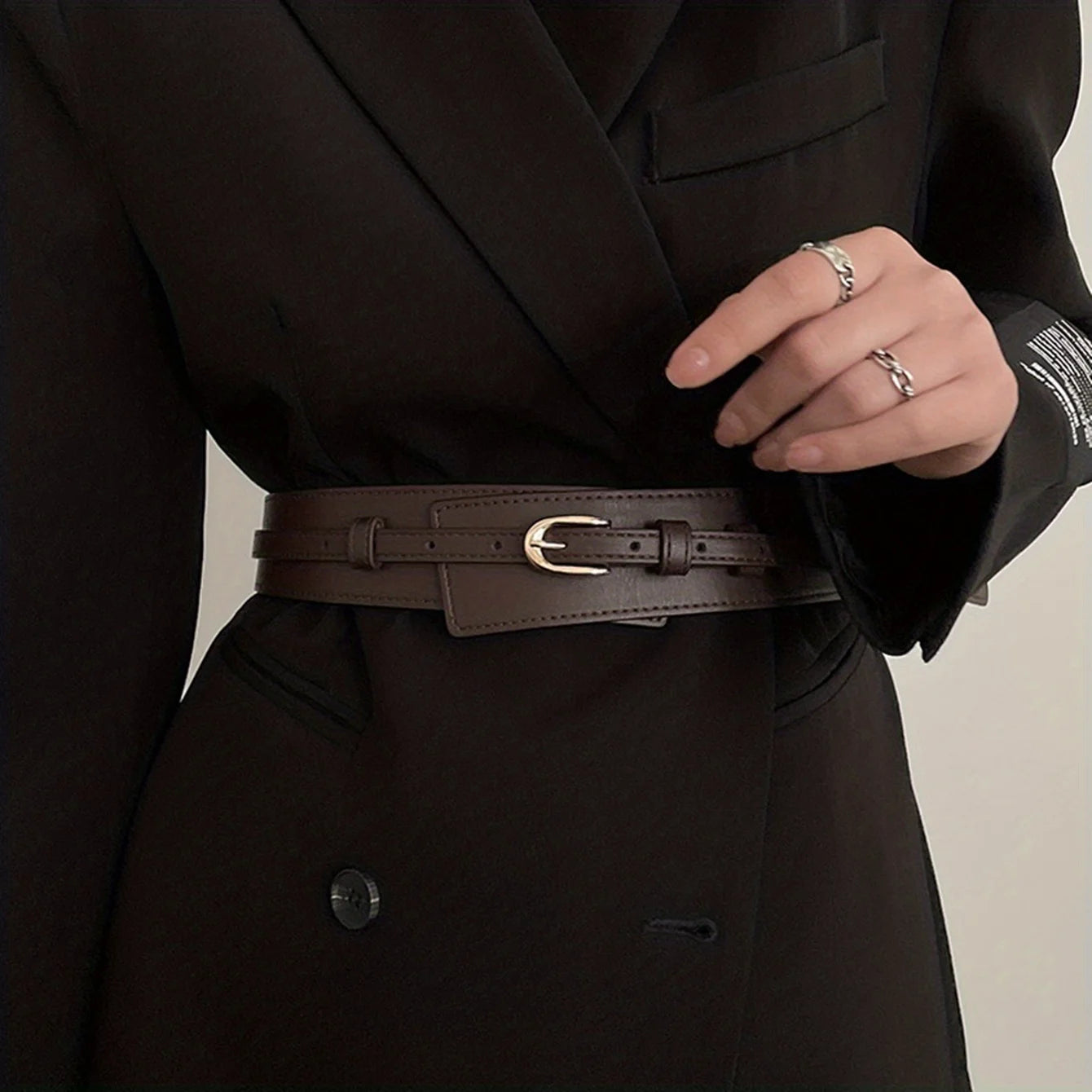 Chic vintage wide belt for women in brown leather with a classic buckle, styled on a black coat