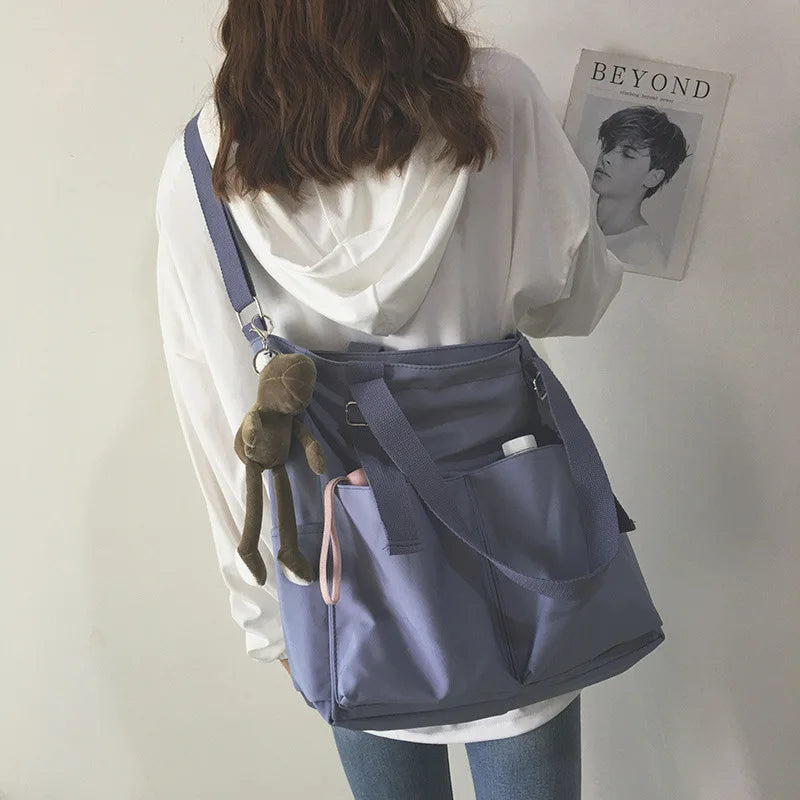 Stylish waterproof ladies handbag in lavender with multiple pockets and a cute keychain accessory