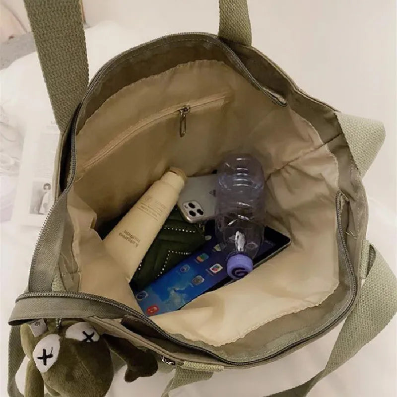 Interior view of a waterproof ladies handbag showing organized items including a water bottle and phone