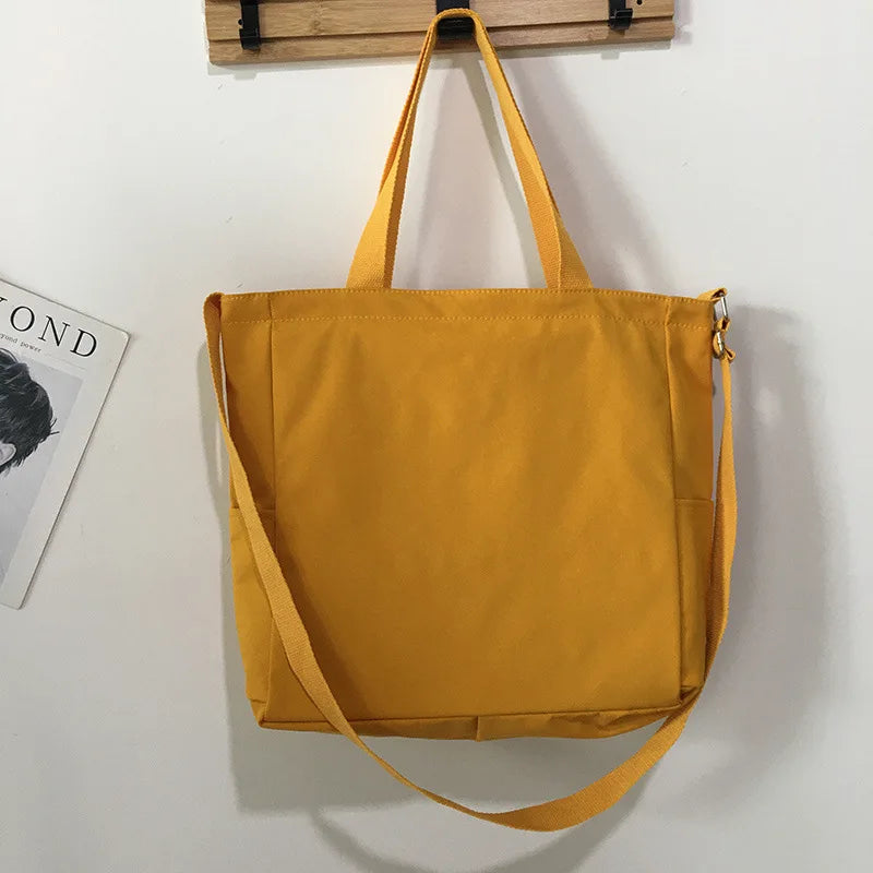 Bright yellow waterproof ladies handbag with adjustable strap and sturdy handles