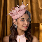Elegant wedding pillbox hat in soft pink with netting and decorative feathers for special occasions