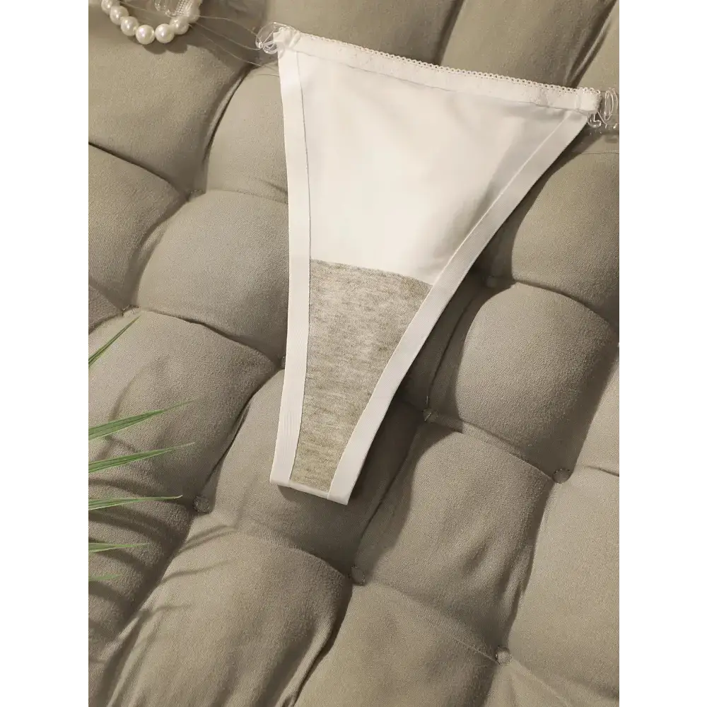 White seamless thong underwear from The Lady's Haven Boutique displayed on a cushioned surface