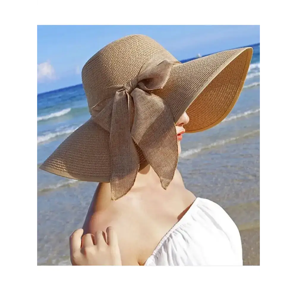 Wide brim floppy hat for women in beige with a decorative bow, perfect for beach outings