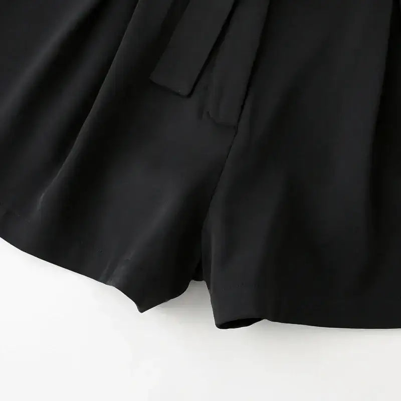 Close-up view of black high waisted shorts featuring a smooth fabric and tailored fit