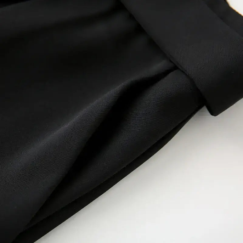 Close-up of black high waisted shorts fabric texture and waistband detailing