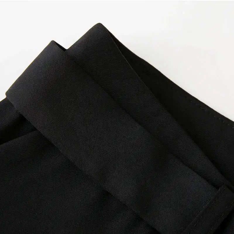 Close-up view of black high waisted shorts waistband with stitched detailing