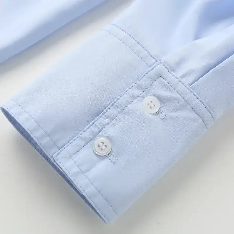 Close-up of light blue spring long sleeve office shirt cuff with white buttons and neat stitching