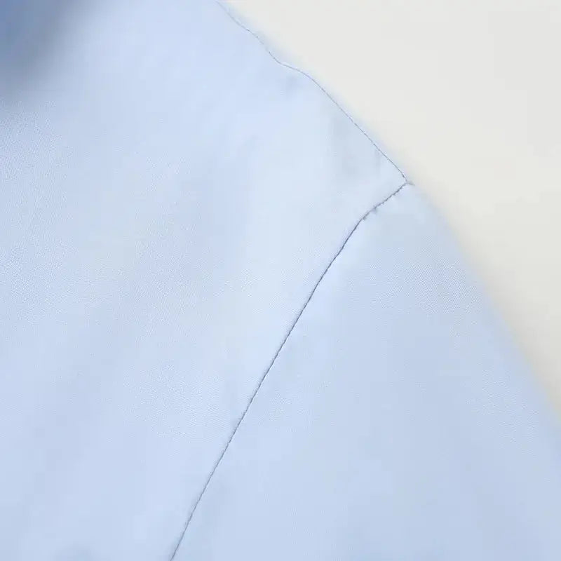 Close-up detail of light blue fabric seam on spring long sleeve office shirt