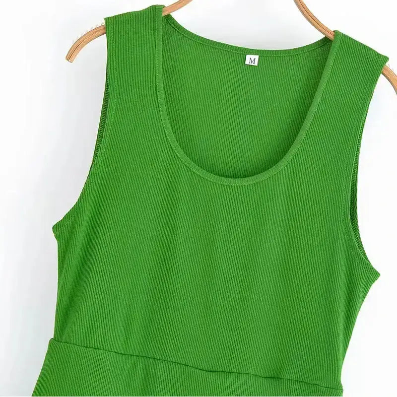 Close-up of sleeveless green maxi dress with ribbed fabric on a wooden hanger