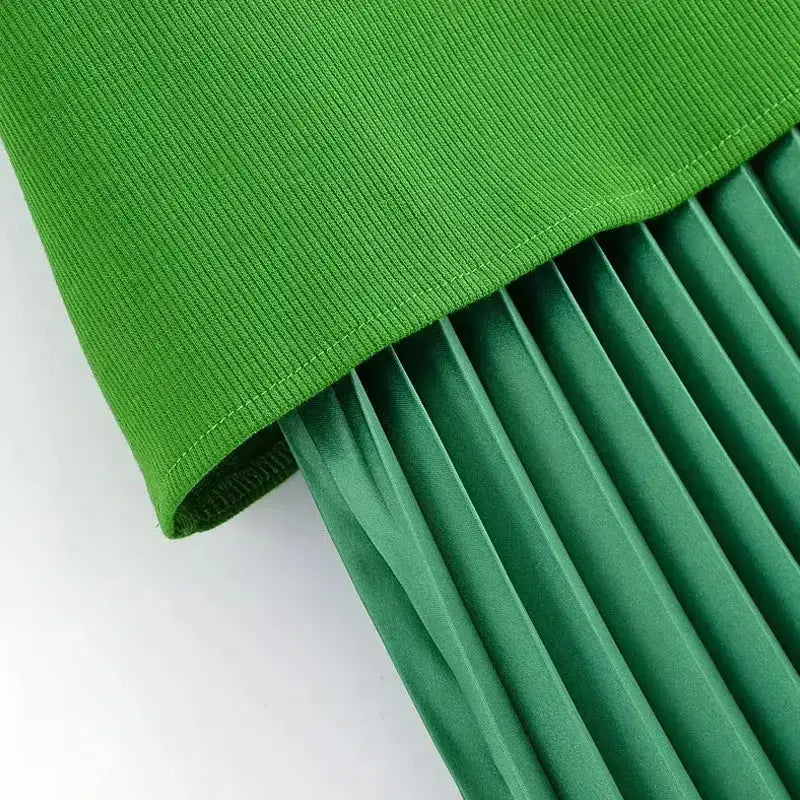 Close-up of ribbed top and pleated skirt details on sleeveless green maxi dress