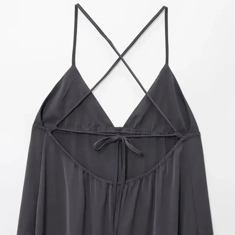 Black sleeveless backless midi dress with thin crisscross straps and tie detail on the back