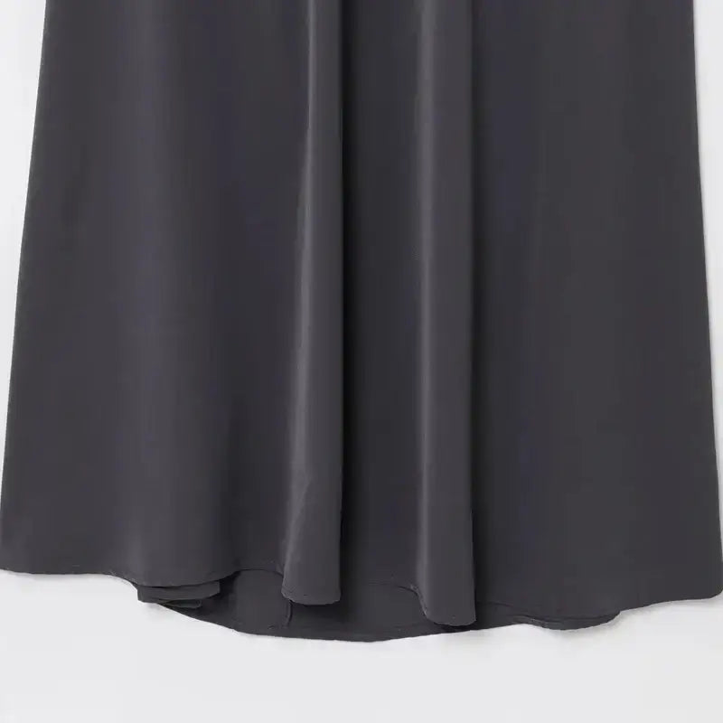 Close-up of dark gray flowing fabric hem of sleeveless backless midi dress from The Lady's Haven Boutique