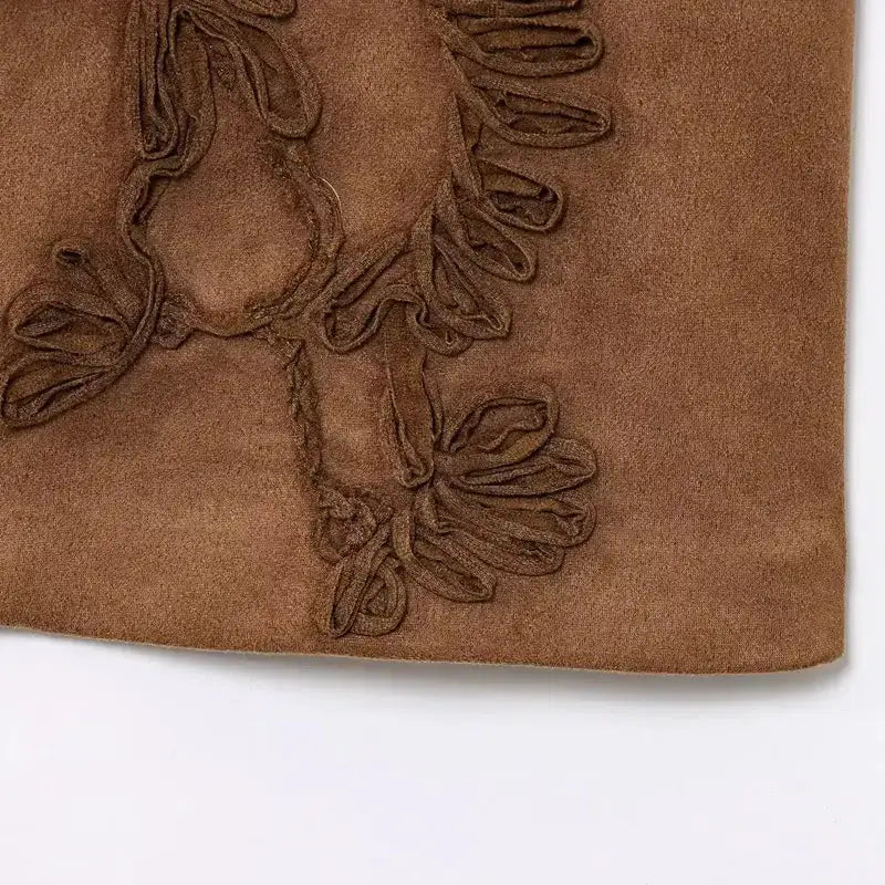 Brown suede detailed section of spring summer cropped vest with intricate stitching