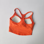 Bright orange womens push up sports bra with crisscross back design for active workouts