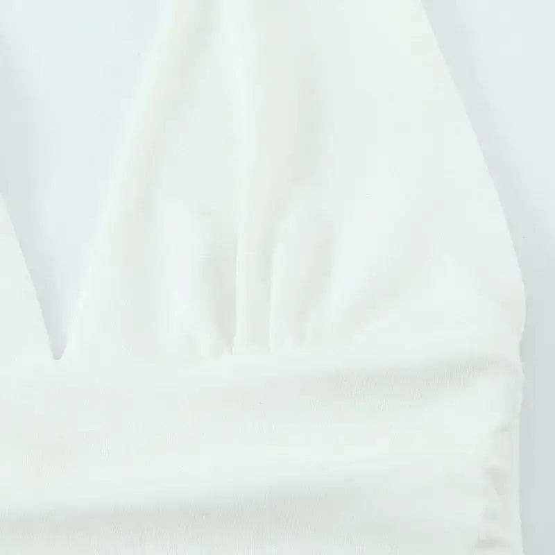 Close-up of white fabric detail of off shoulder halter mini dress from The Lady's Haven Boutique