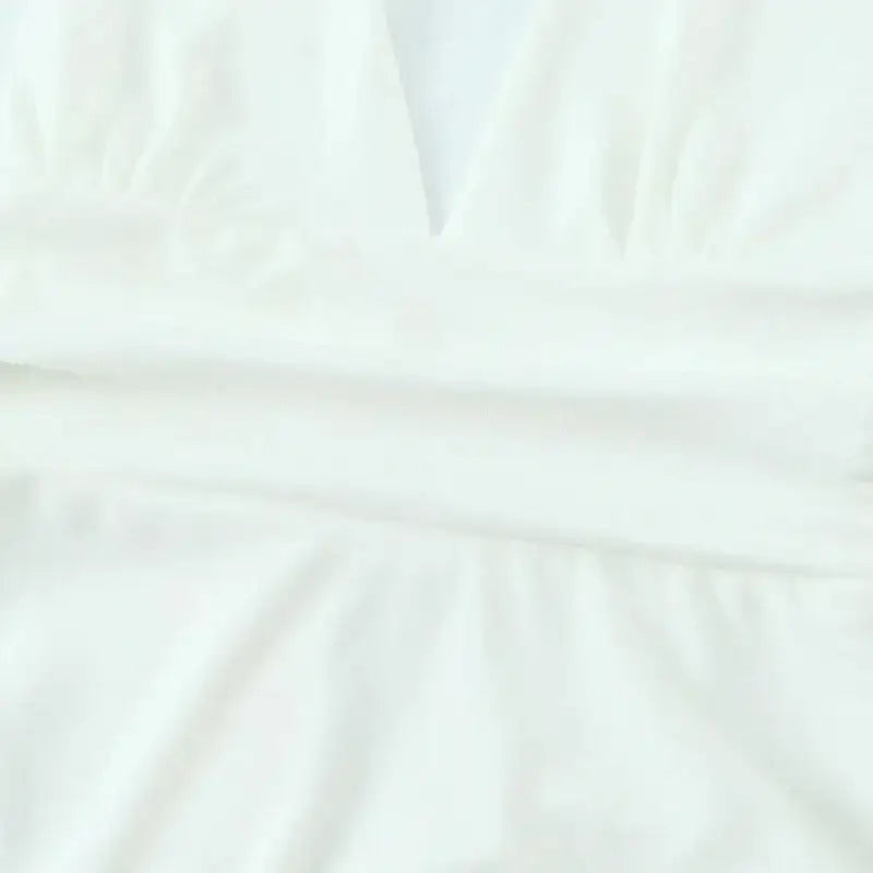 Close-up detail of white fabric on off shoulder halter mini dress from The Lady's Haven Boutique