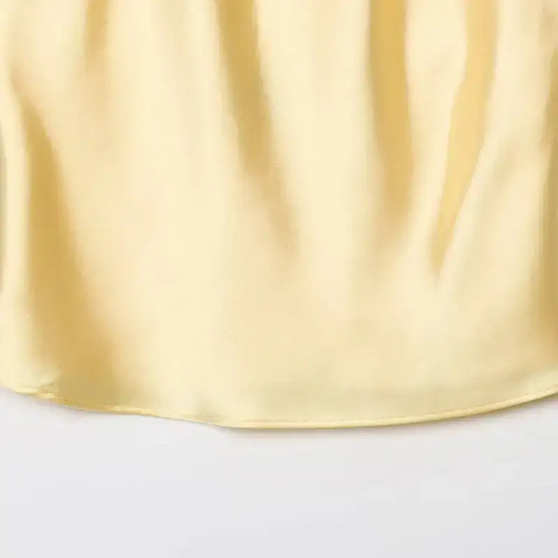 Soft yellow satin fabric detail of halter crop tops from The Lady's Haven Boutique