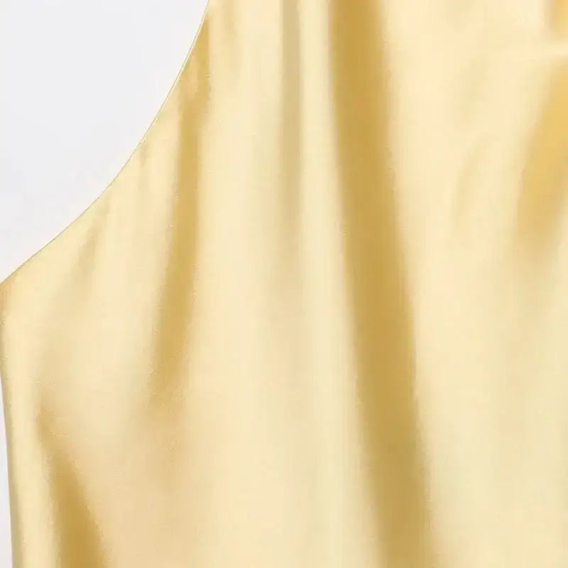 Close-up of pale yellow satin fabric halter crop tops by The Lady's Haven Boutique