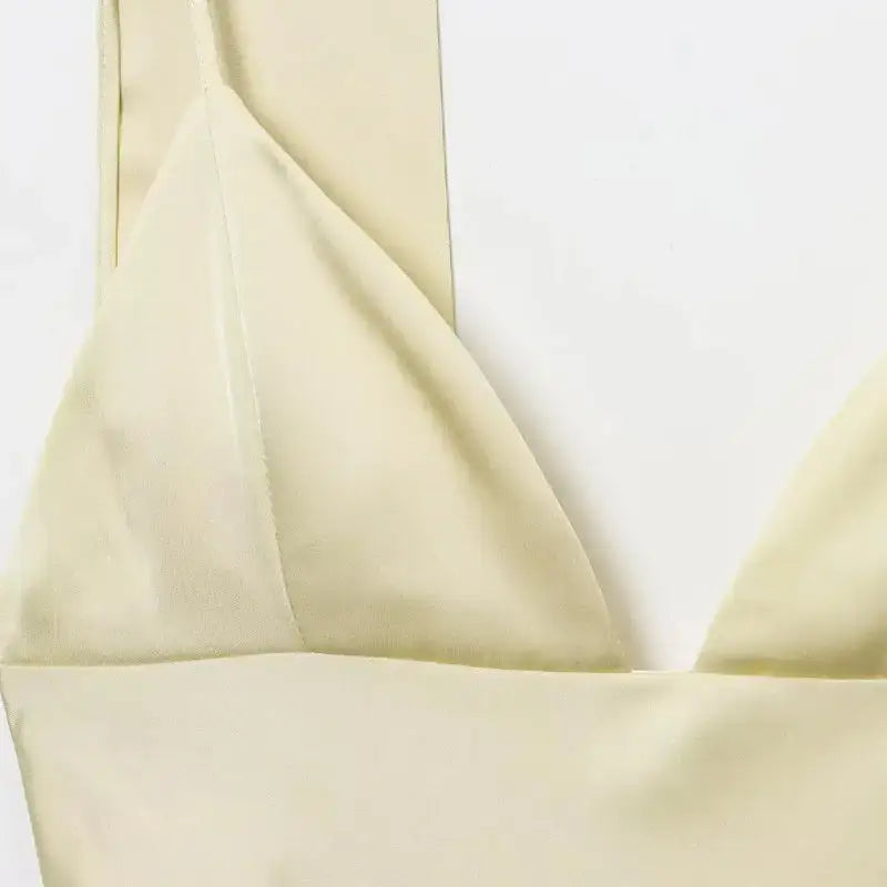 Close-up of a cream-colored sleeveless satin formal dress with thin straps from The Lady's Haven Boutique