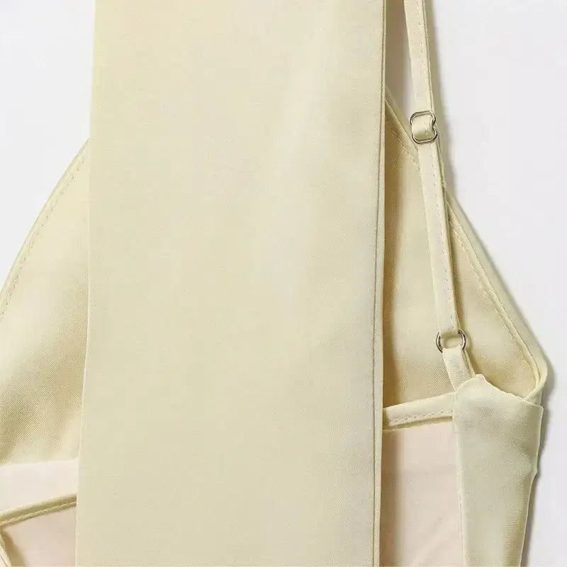 Close-up of a cream sleeveless satin formal dress with adjustable straps from The Lady's Haven Boutique