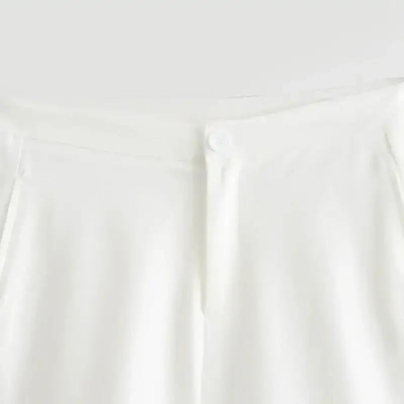 Close-up of white shorts waistband with button for summer office vest and shorts outfit