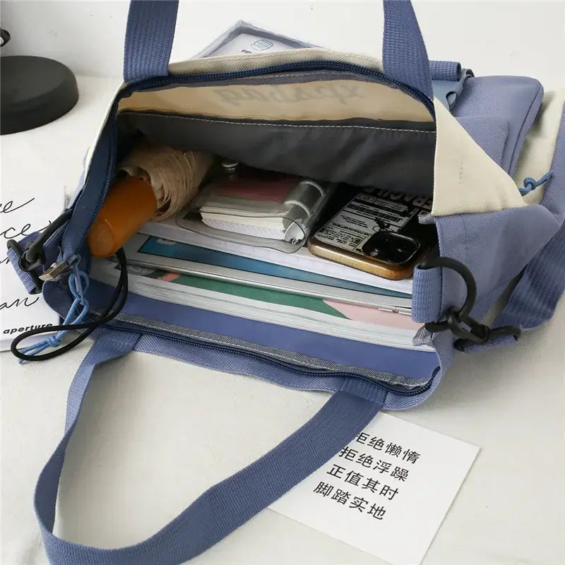Interior view of a large capacity ladies handbag with organized items like a phone and umbrella