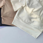 Assorted yoga clothes for women including cream and tan breathable tops for comfort during workouts