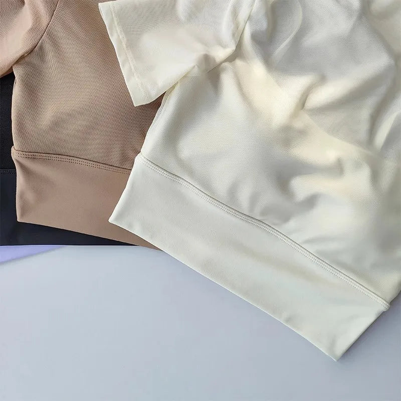 Assorted yoga clothes for women including cream and tan breathable tops for comfort during workouts