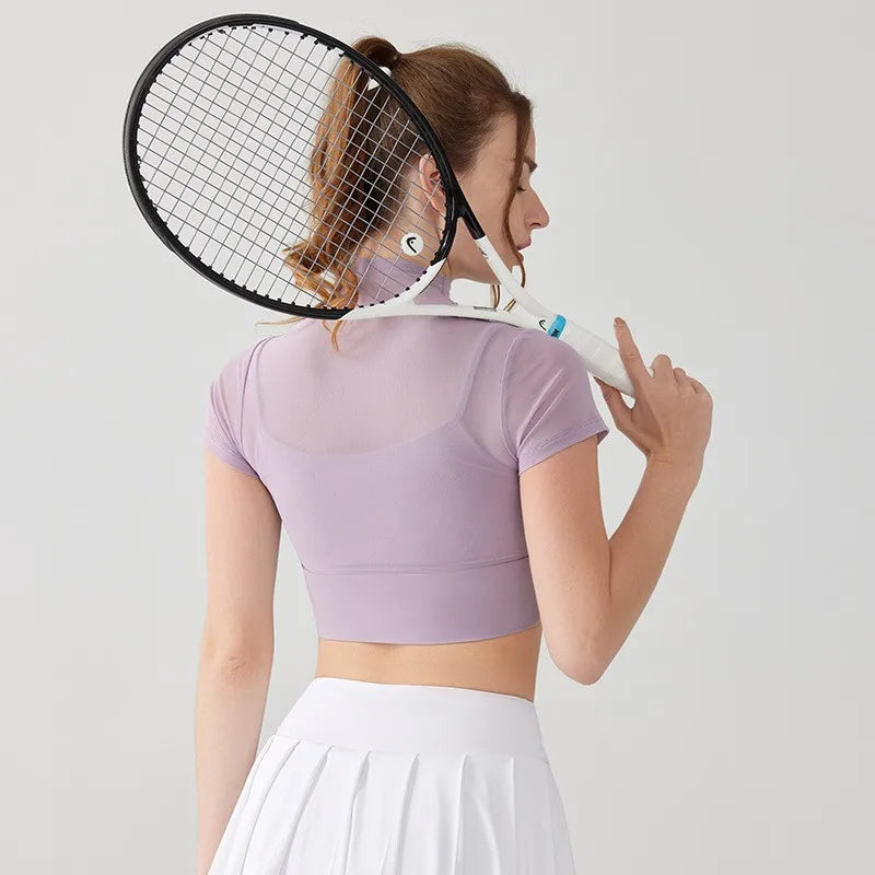 Back view of a woman wearing lavender yoga clothes for women with a tennis racket