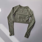 Light gray cropped long-sleeve top designed as yoga fitness tops for women with breathable fabric and thumbholes
